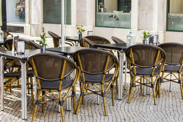 LISBON, PORTUGAL, on June 22, 2017. Tables in cafe under the open sky in a historical part of the city wait visitors in early morning - Valokuva, kuva