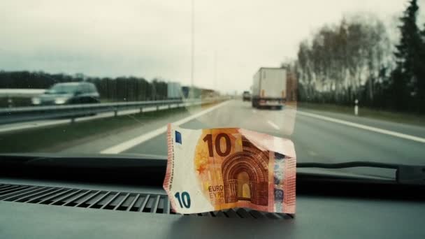 Δέκα ευρώ τοποθετούνται στο αυτοκίνητο στο μπροστινό γυαλί. Κοντινό πλάνο - Πλάνα, βίντεο