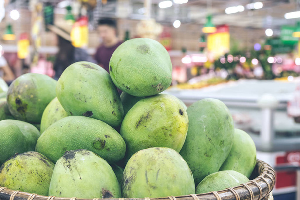 Las frutas tropicales cierran los mangos verdes en la tienda asiática. Isla de Bali, Indonesia. Mercado ecológico
. - Foto, Imagen