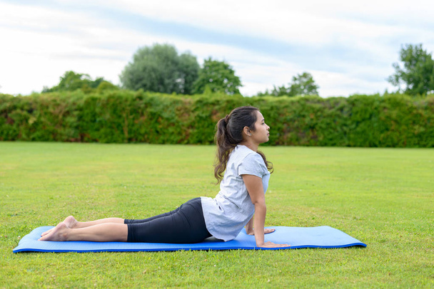 Teenage girl practising yoga outdoors - Foto, imagen