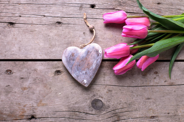 Bright pink tulips and decorative rustic heart  - Zdjęcie, obraz