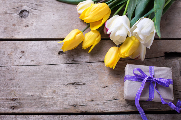 Spring tulips and wrapped  box  on vintage wooden background. - Valokuva, kuva