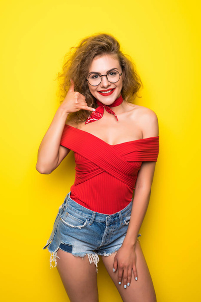 Young cool woman in red on yellow background - Photo, Image