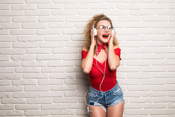 Молодая женщина красивая прослушивающая музыка делает селфи со смартфоном музыкальной социальной сети
 - Фото, изображение