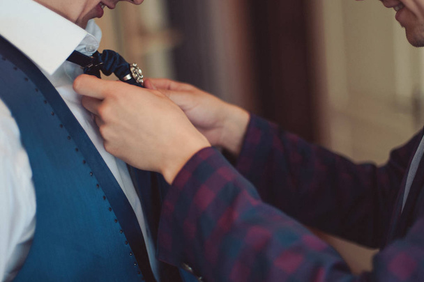 Ο γαμπρός σε ένα κοστούμι διορθώνει μια γραβάτα. Αξεσουάρ του γαμπρού - Φωτογραφία, εικόνα