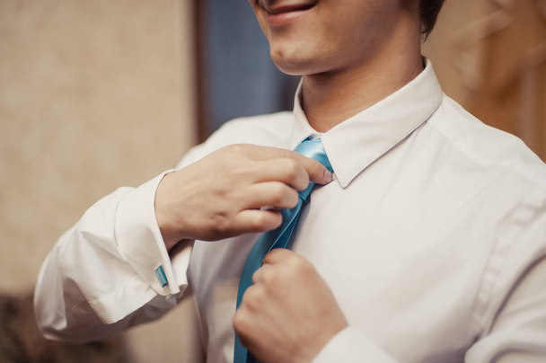 Le marié en costume corrige une cravate. Accessoires de Groom
 - Photo, image