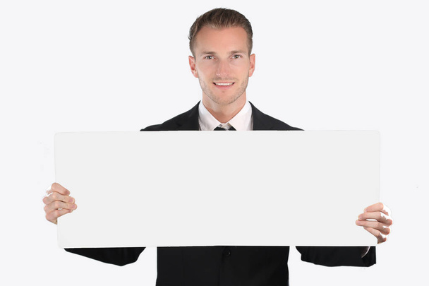 Cheerful young businessman showing blank signboard - Foto, imagen