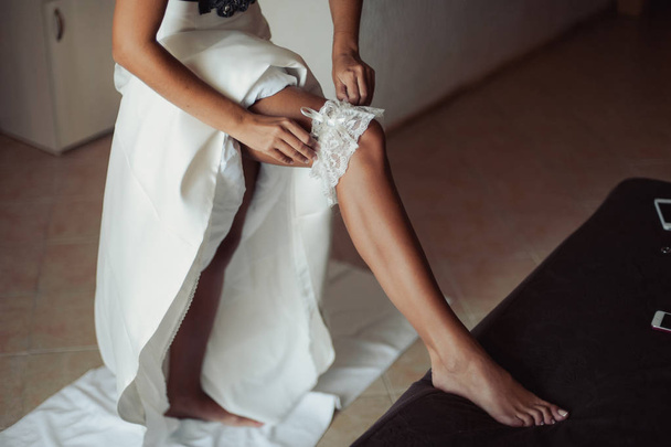 nevěsta klade na podvazkový - Fotografie, Obrázek