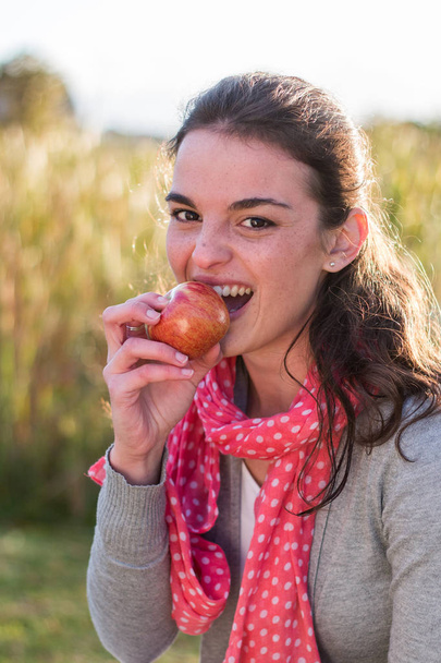 Menina mordendo maçã vermelha
 - Foto, Imagem