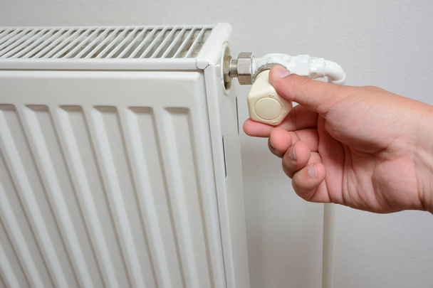 Hand adjusting the knob of heating radiator (individual heating system) - Photo, Image