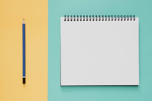 Office workplace minimal concept. Blank notebook, pencil on yell - Фото, зображення
