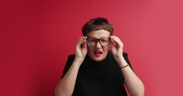 žena snaží descern něco, třít její oči a brýle - Záběry, video