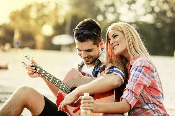 Young Man Playing Guitar to his Girlfriend - Foto, afbeelding