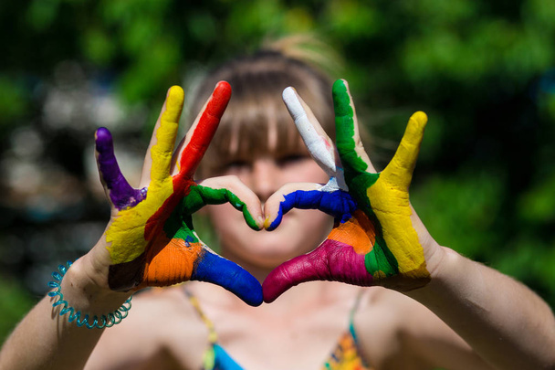 Kids hands in color paints make a heart shape, focus on hands - Photo, Image