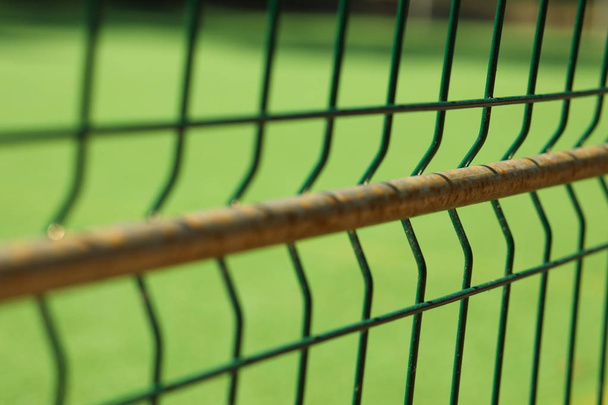 Soft focus, abstract football field with fence on foreground - Foto, afbeelding