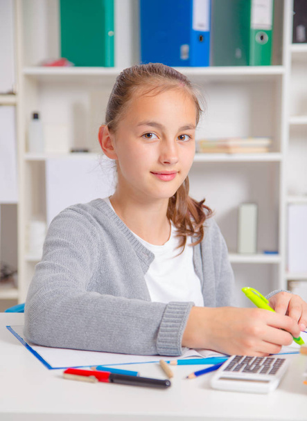 Teenage girl preparing for exams. Teenage girl doing homework for school. - Foto, afbeelding