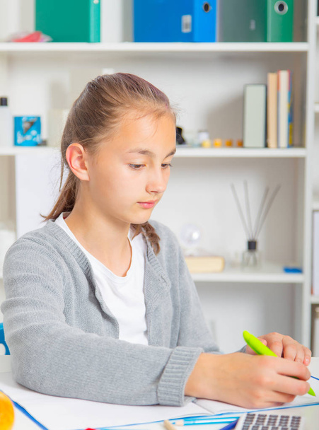 Teenage girl preparing for exams. Teenage girl doing homework for school. - Fotó, kép