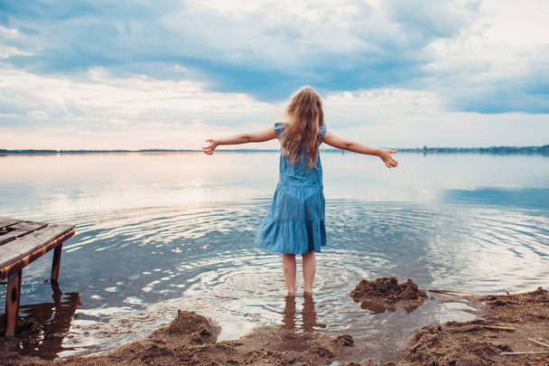 Schattig klein meisje plezier op het meer. - Foto, afbeelding