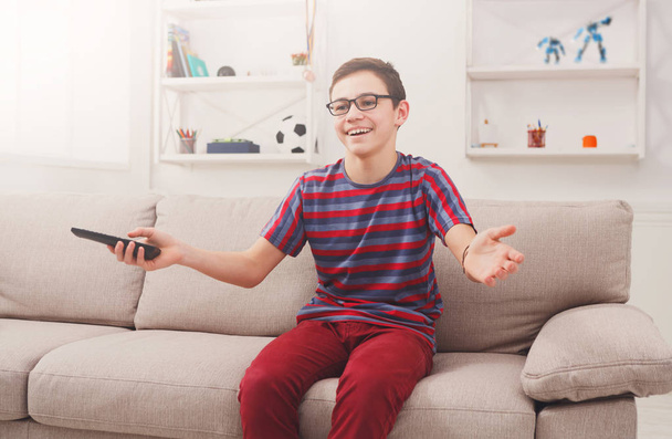 Cheerful boy watching funny TV show at home - Foto, afbeelding