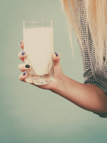 Woman hand holding glass of milk - Photo, image
