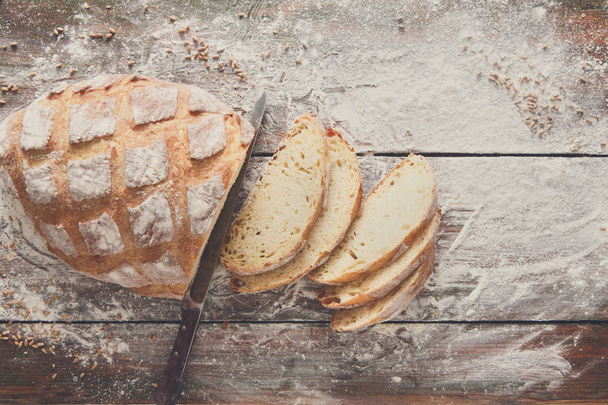 Backhauskonzept Hintergrund. weiße Scheiben Brot und Messer - Foto, Bild