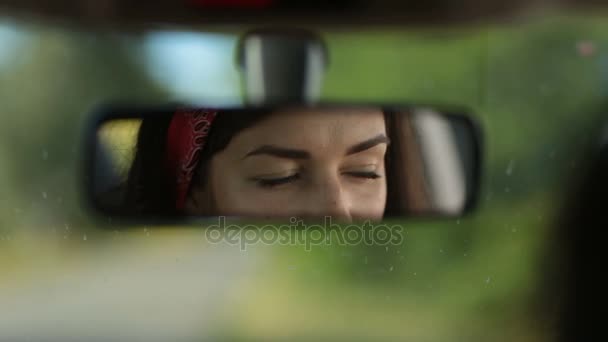 Weerspiegeling van leuke vrouw in auto rearview spiegel - Video