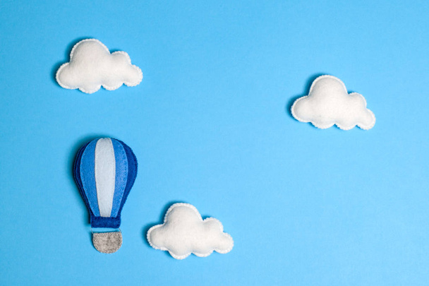 Hot air balloon in blue sky with clouds, frame, copyspace. Hand made felt toys. - Photo, Image