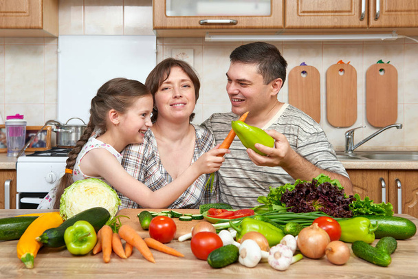 οικογένεια που το μαγείρεμα στην κουζίνα, εσωτερικό στο σπίτι, φρέσκα φρούτα και λαχανικά, έννοια υγιεινή τροφή, γυναίκα, άνδρα και παιδιά - Φωτογραφία, εικόνα