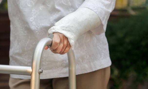 starší žena zlomené zápěstí pomocí walker na dvorku - Fotografie, Obrázek