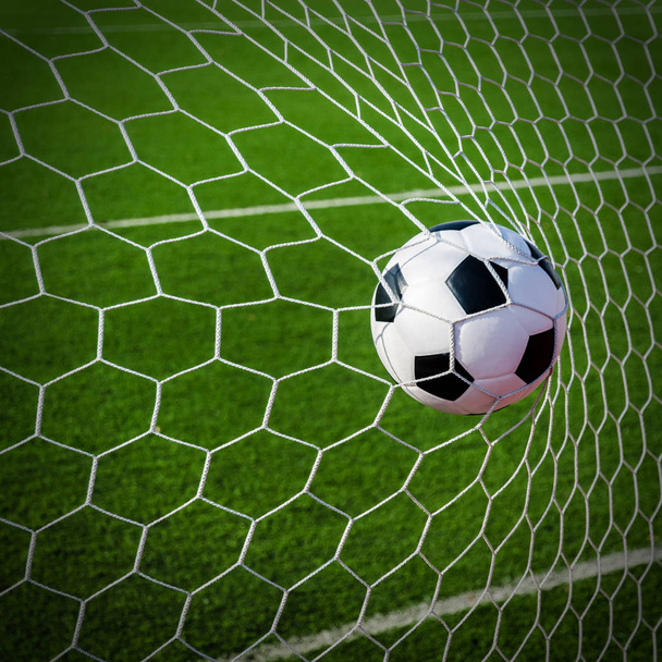 Soccer football in Goal net with green grass field. - Φωτογραφία, εικόνα