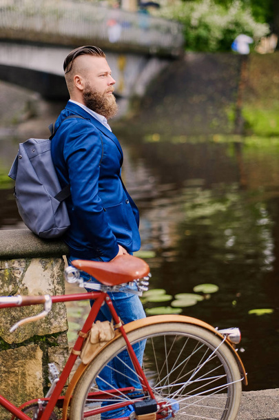 Varón barbudo con chaqueta azul y bicicleta
 - Foto, Imagen