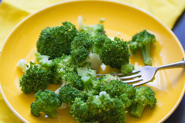 Fresh broccoli cut in yellow plate - Foto, Imagem