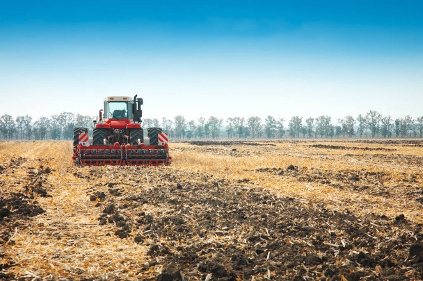 Современный трактор в поле с комплексом для вспашки
. - Фото, изображение