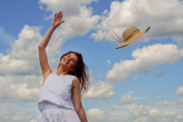 El viento sopla el sombrero de la cabeza de las mujeres
 - Foto, imagen