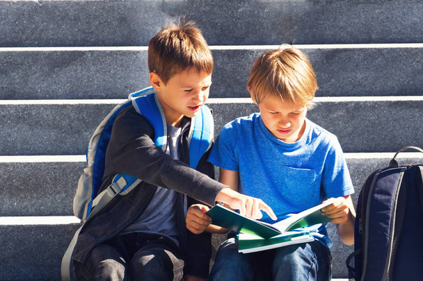 Due ragazzi che fanno i compiti all'aperto. Concetto di ritorno a scuola
. - Foto, immagini