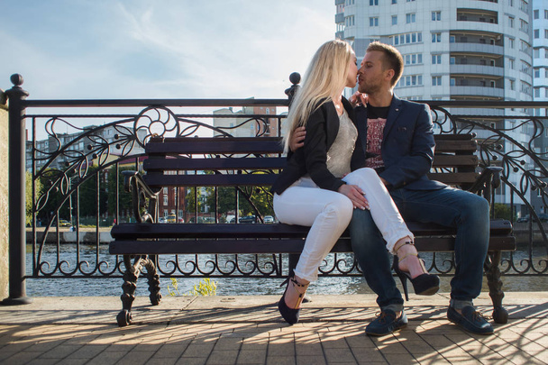 Молодые взрослые мужчина и женщина на скамейке в городе. Романтическое свидание
 - Фото, изображение