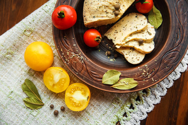 zelfgemaakte kaas, tomaten met kruid kruid in landelijke pottery.rough tabel servet. - Foto, afbeelding