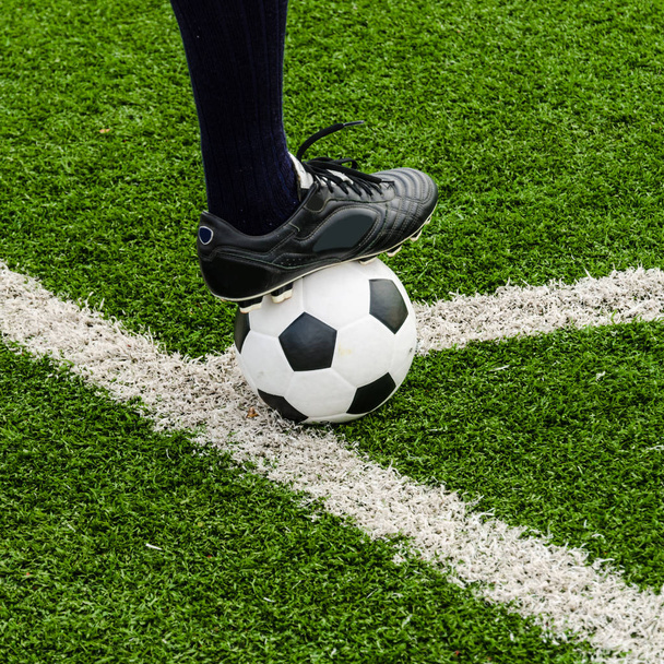 Bola de futebol e sapatos em um campo de grama verde
. - Foto, Imagem