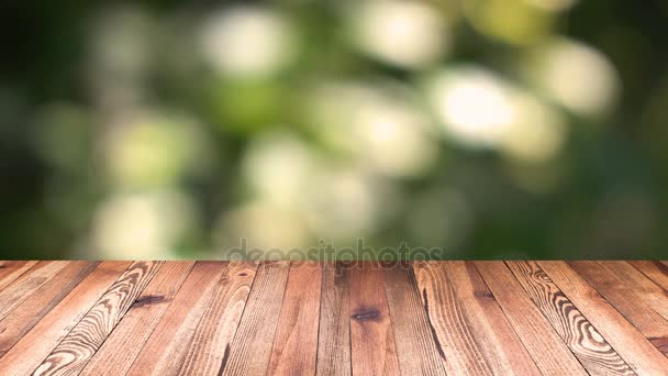 Perspectief hout en bokeh licht achtergrond. product weergave sjabloon. Houten tafelblad op vervagen natuurlijk groene blad achtergrond verplaatsen - Video