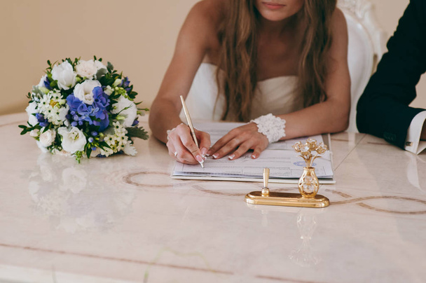 Signature Ceremony. The bride and groom sign the documents about the marriage - Photo, image