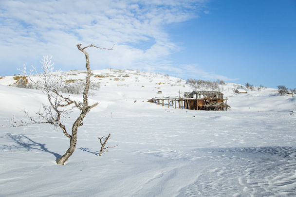 Vanha, hylätty kuparikaivos lumisessa Norjassa.
 - Valokuva, kuva