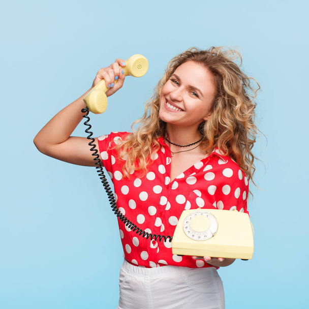 Cheerful woman posing with old phone - Foto, Bild
