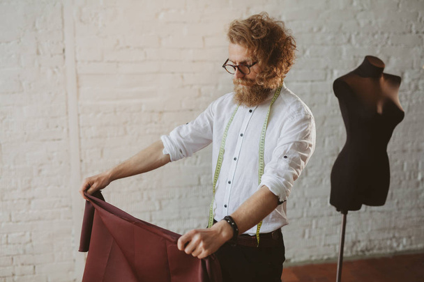 Bearded man holding fabric standing - Zdjęcie, obraz