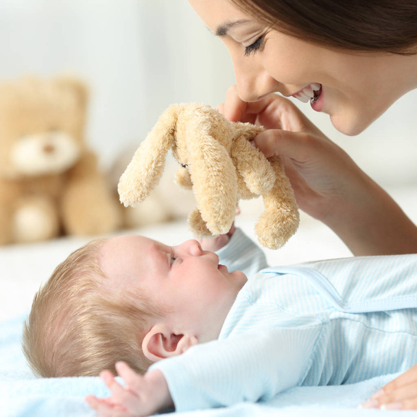 Mother playing with her baby with a teddy - Foto, Bild