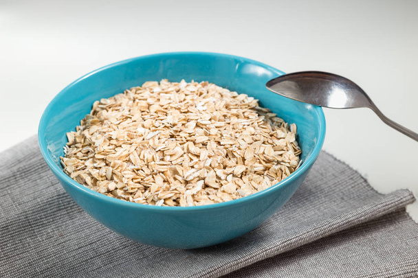 Oat flakes in blue bowl ready to cook - Photo, Image