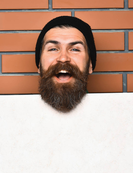 Bearded brutal caucasian hipster with white paper sheet - Fotó, kép