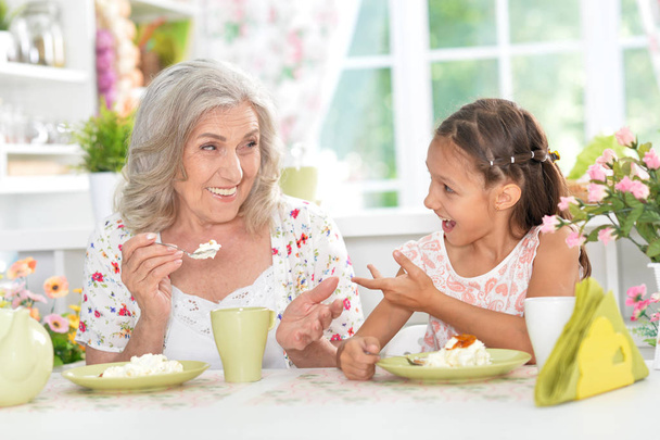 grandmother and granddaughter having breakfast - Fotó, kép