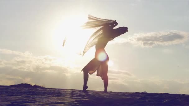 Silhouet van een dansende vrouw bij zonsondergang - Video