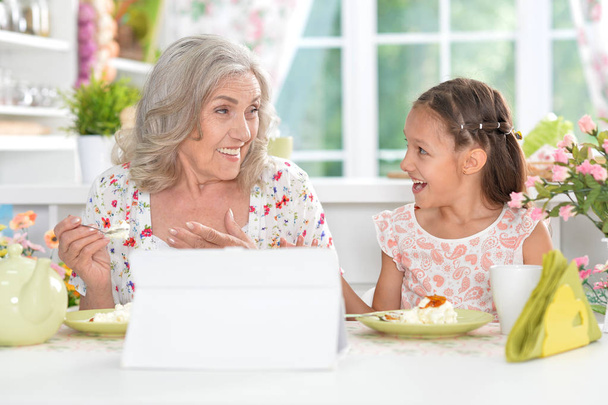 grandmother and granddaughter having breakfast - Фото, изображение