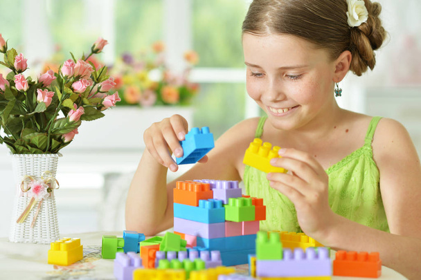 Cute girl playing with plastic blocks - Foto, afbeelding